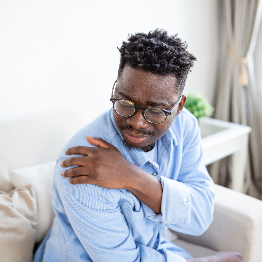 A man holding his shoulder in discomfort.