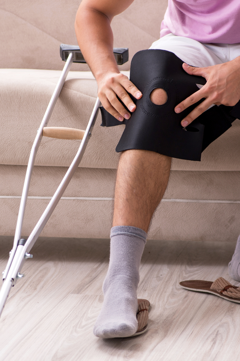 A person on a sofa with a knee injury.
